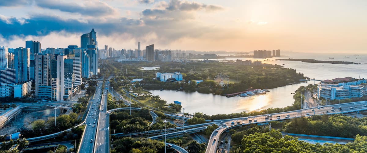 A cityscape with high-rise buildings, a river, and a bridge.