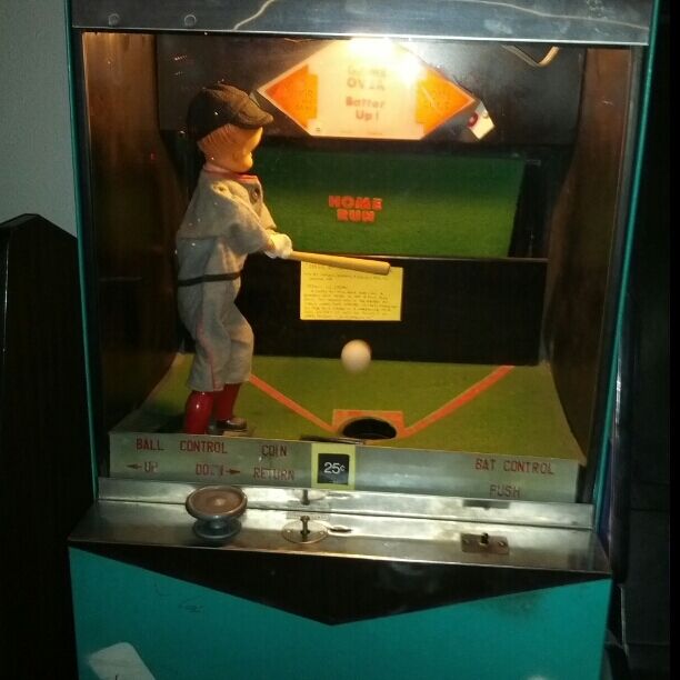 Vintage baseball arcade game using a fan blower to suspend a ping pong ball in the air while the user swings the bat. 
