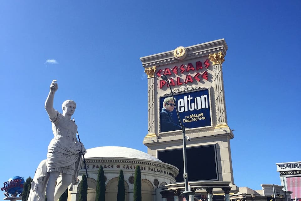 A statue, Caesars Palace sign, and a dome structure.