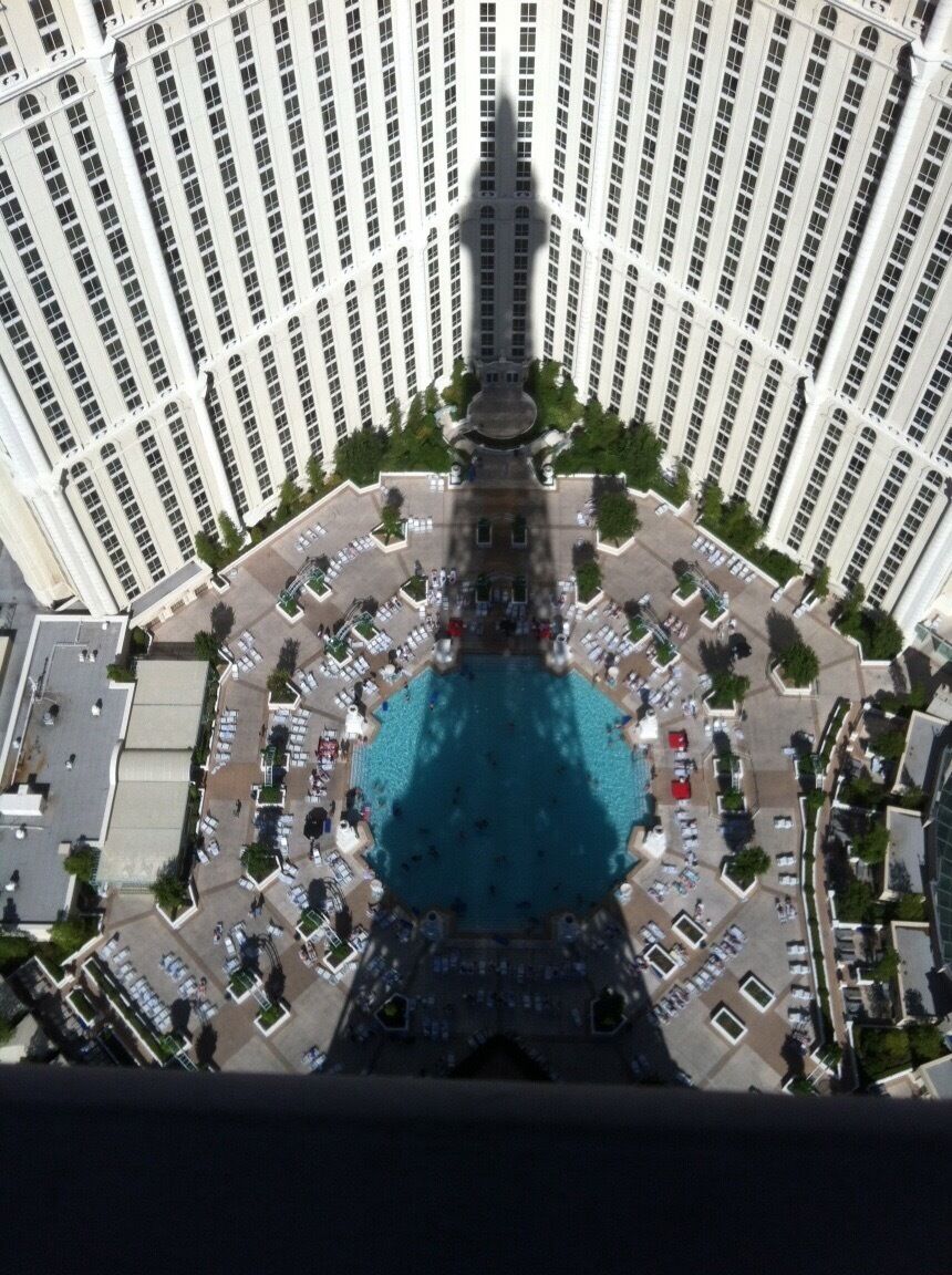 Vista aérea de un edificio alto con un patio central y una piscina.