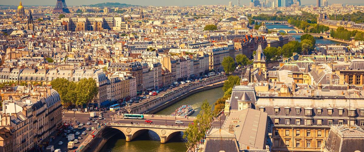 A panoramic view of Paris, including the Eiffel Tower, the Seine River, and the cityscape with notable landmarks.
