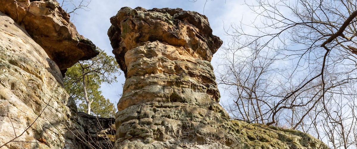 A rocky cliff formation with a prominent vertical rock protrusion.