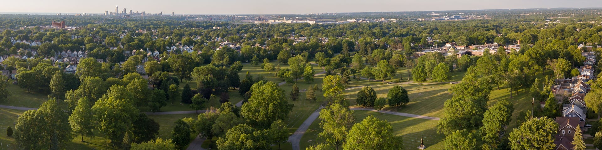 A residential area with houses, trees, and a cemetery.