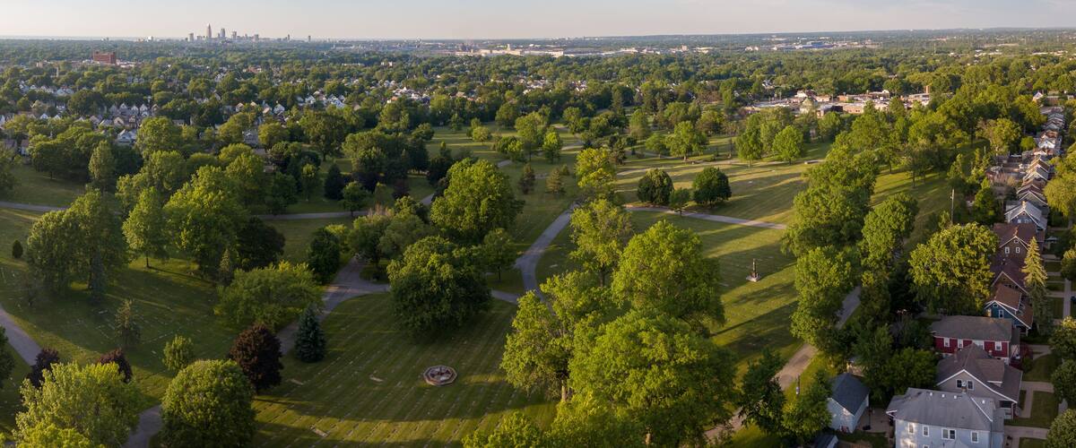 A residential area with houses, trees, and a cemetery.