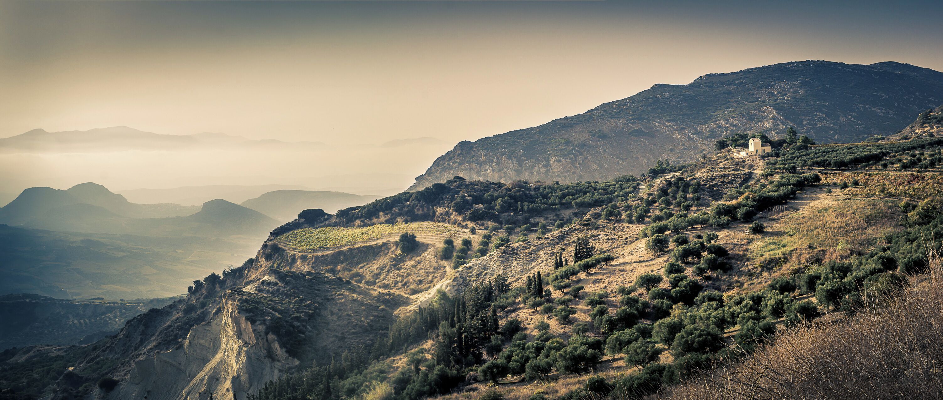 Just after the mountain top villages while on the way from Heraklion to Malata I saw this amazing view with what I believe is a farmhouse on the edge of a cliff.. Would likely be even better during sunset.

(I'm not 100% sure exactly where #ontheroad this view is so placed the marker where I think it was)