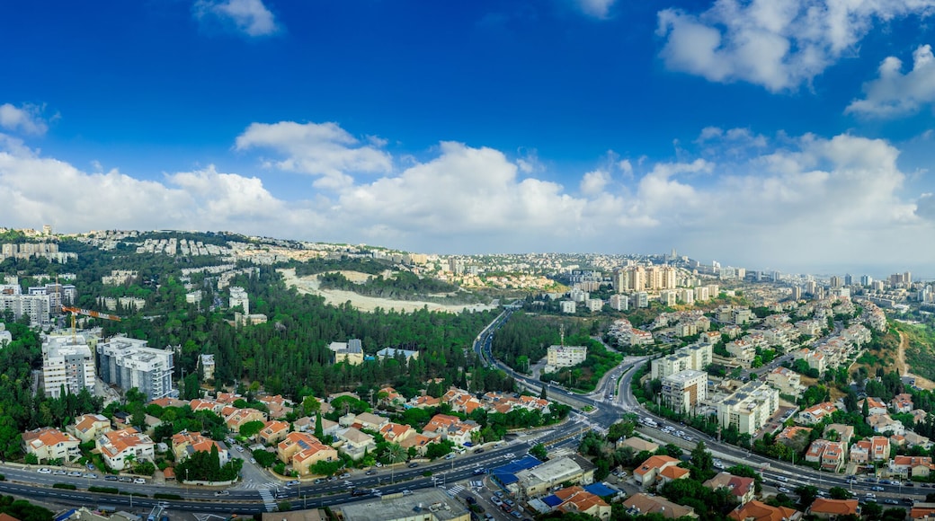 Aerial panorama of Ramot Remez and Romema modern neighborhoods with major intersecting roads modern houses with white walls and red roofs, high rising new construction in Haifa Israel with blue sky