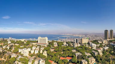 A coastal cityscape with dense urban development, prominent buildings, and a clear view of the sea.