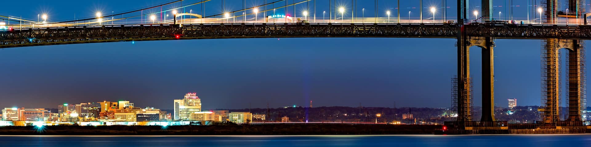 Wilmington skyline framed by Delaware Memorial Bridge, viewed from New Jersey, across the Delaware River. Wilmington is the largest city in the state of Delaware.