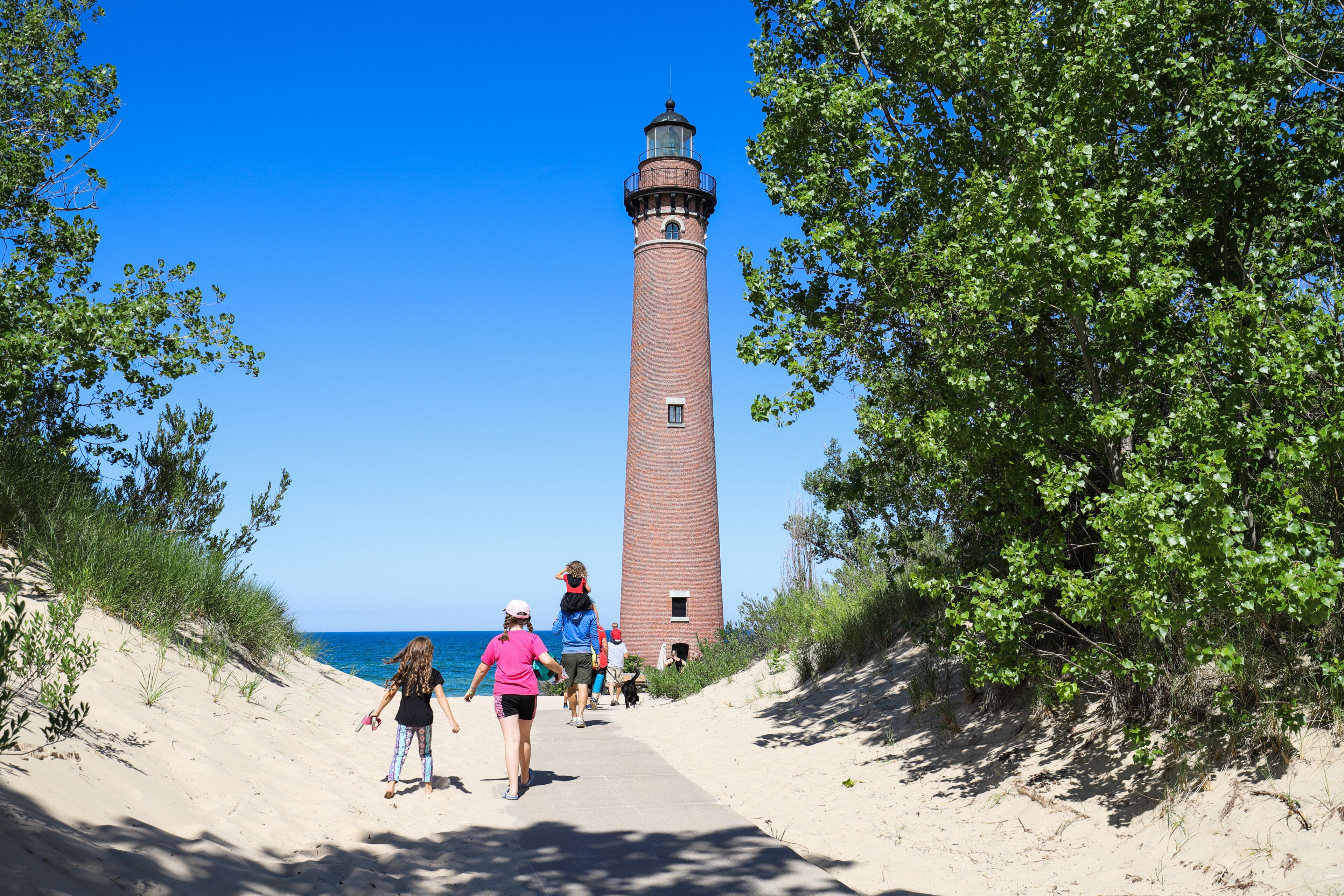 People walking to see Little Sable Point Lighthouse on Lake Michigan