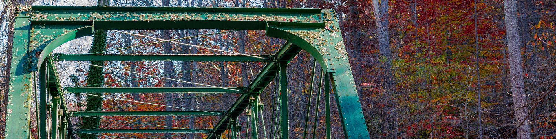 green Bridge over river in autumn with colorful trees