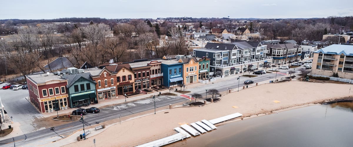 A riverside town with colorful buildings and a sandy beach.