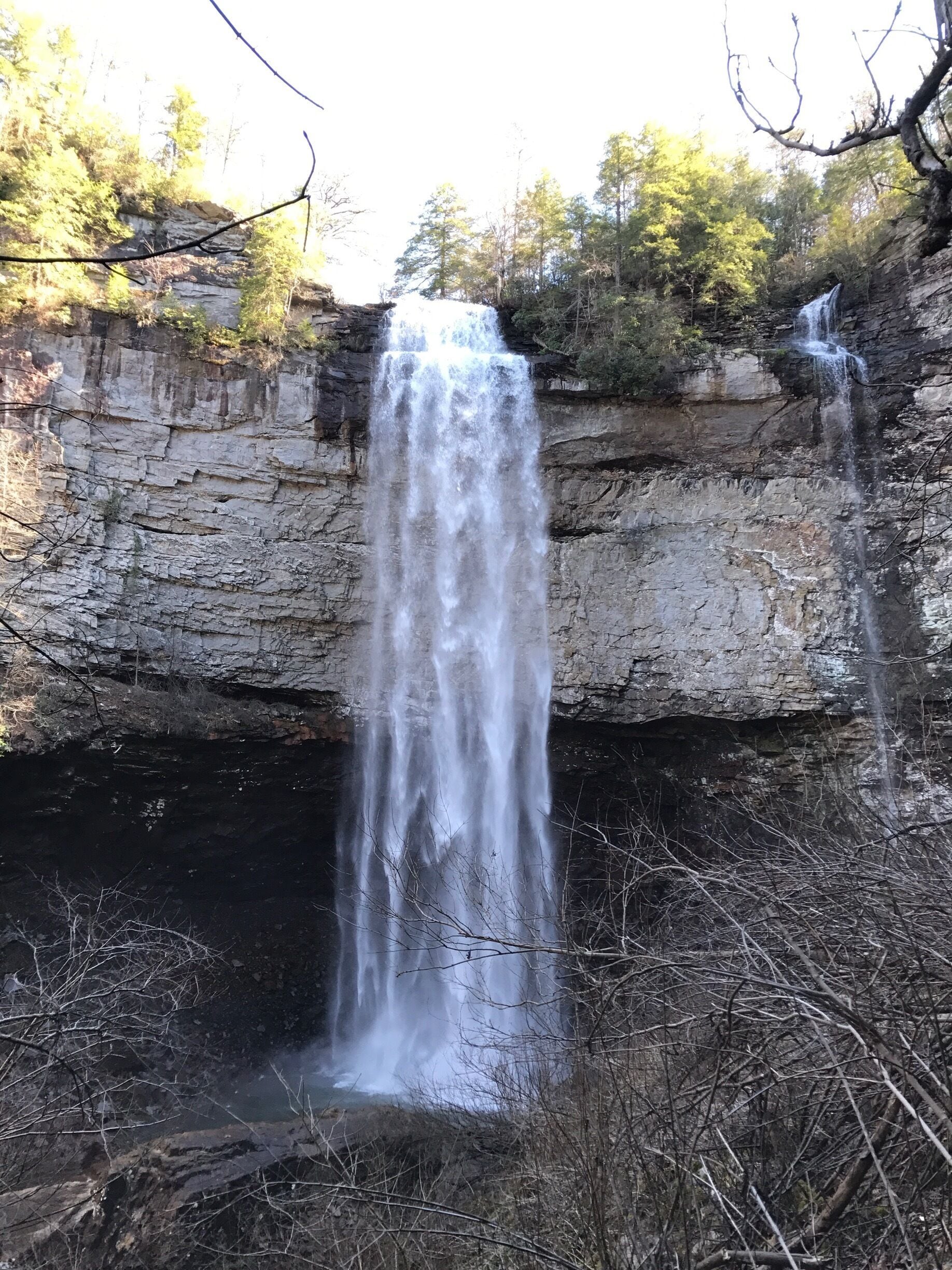 A waterfall cascading down a rocky cliff surrounded by trees.