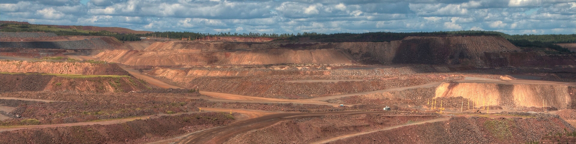 A large open-pit mine with winding roads and a distant horizon.