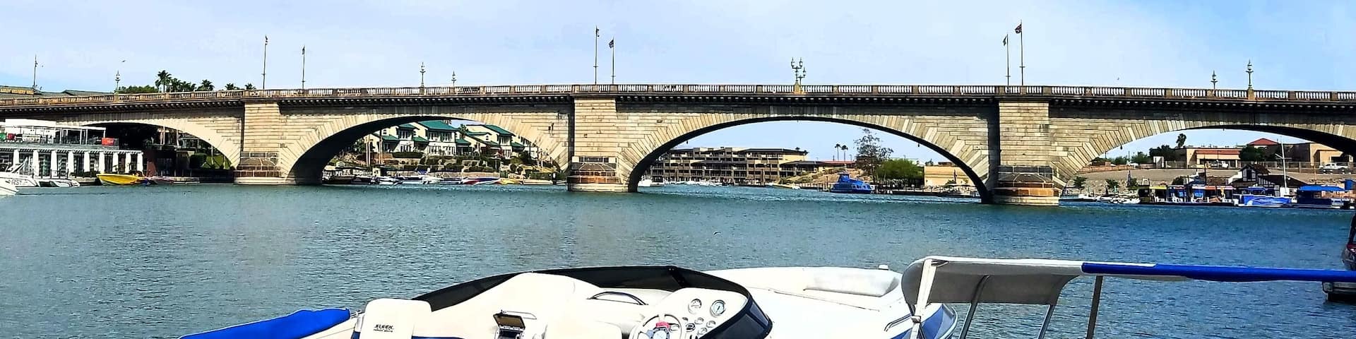 A stone bridge over a river with boats docked nearby.