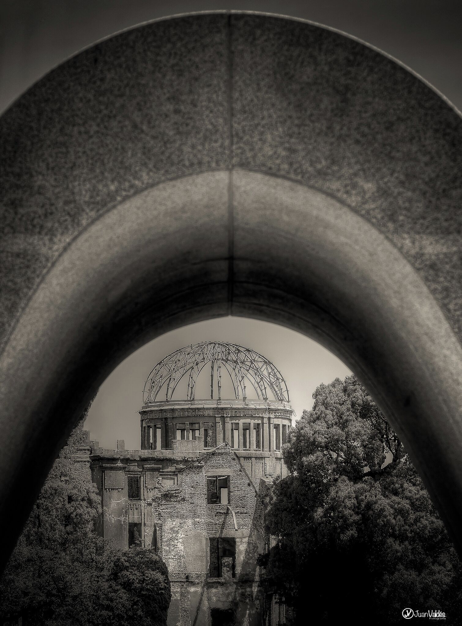 An arched structure framing a historic building with a dome.