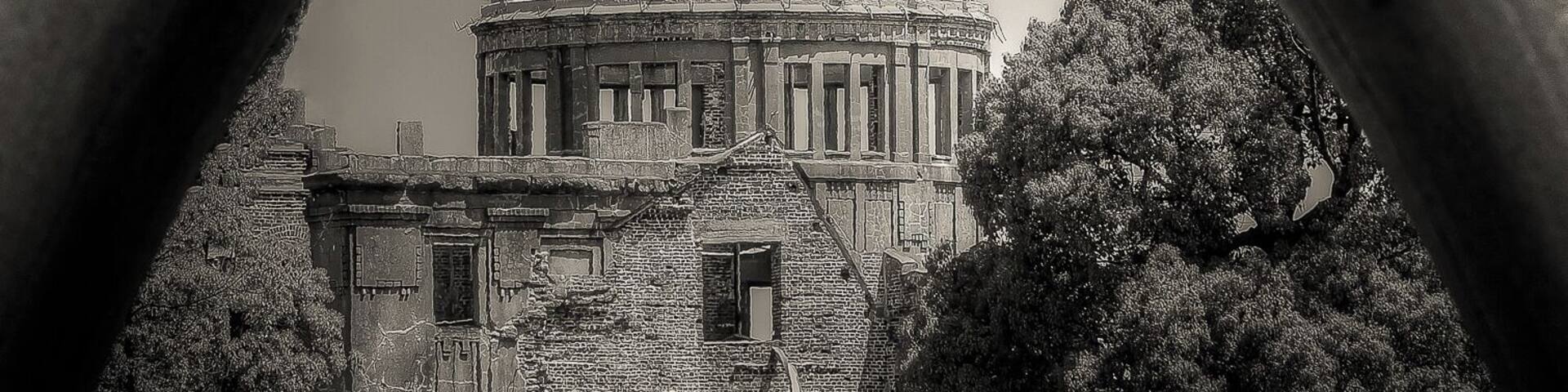 Une structure en arc encadrant un bâtiment historique surmonté d’un dôme.