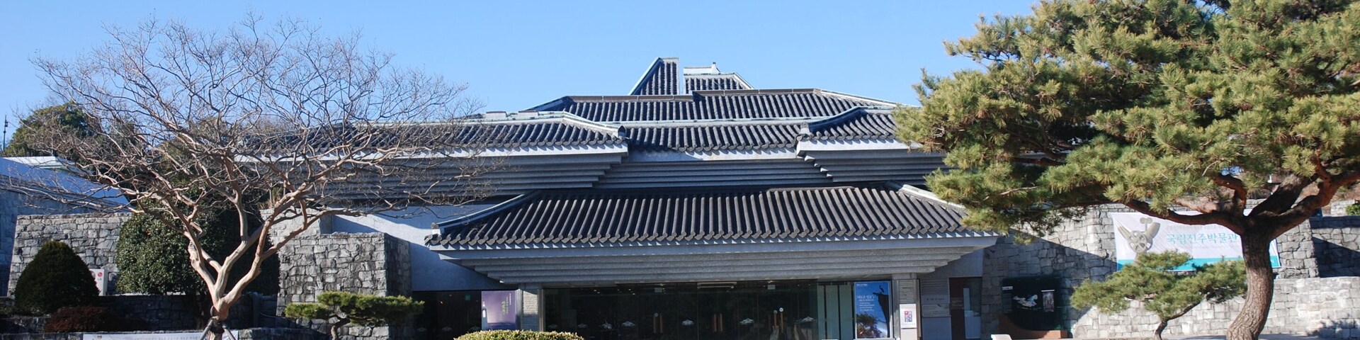 Um edifício japonês tradicional com telhado de telhas e paredes de pedra.