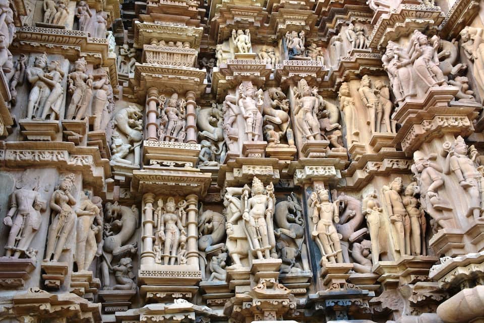 A detailed stone carving of multiple figures in a temple.