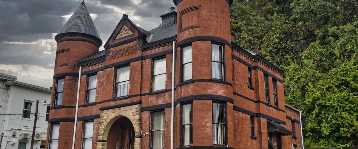 A historic brick building with two towers and a stone archway.