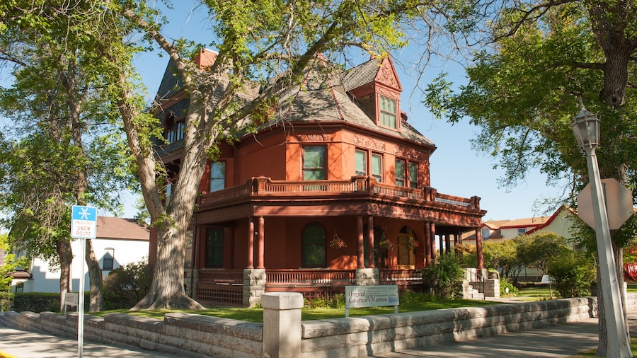A historic red building with a large porch and a tower.