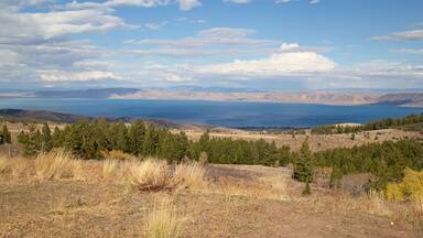 A mountainous landscape with a view of the ocean and distant mountains.