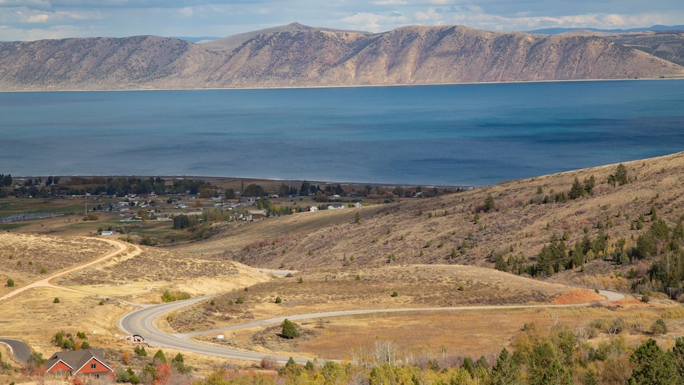 A mountainous landscape with a lake, winding roads, and scattered houses.