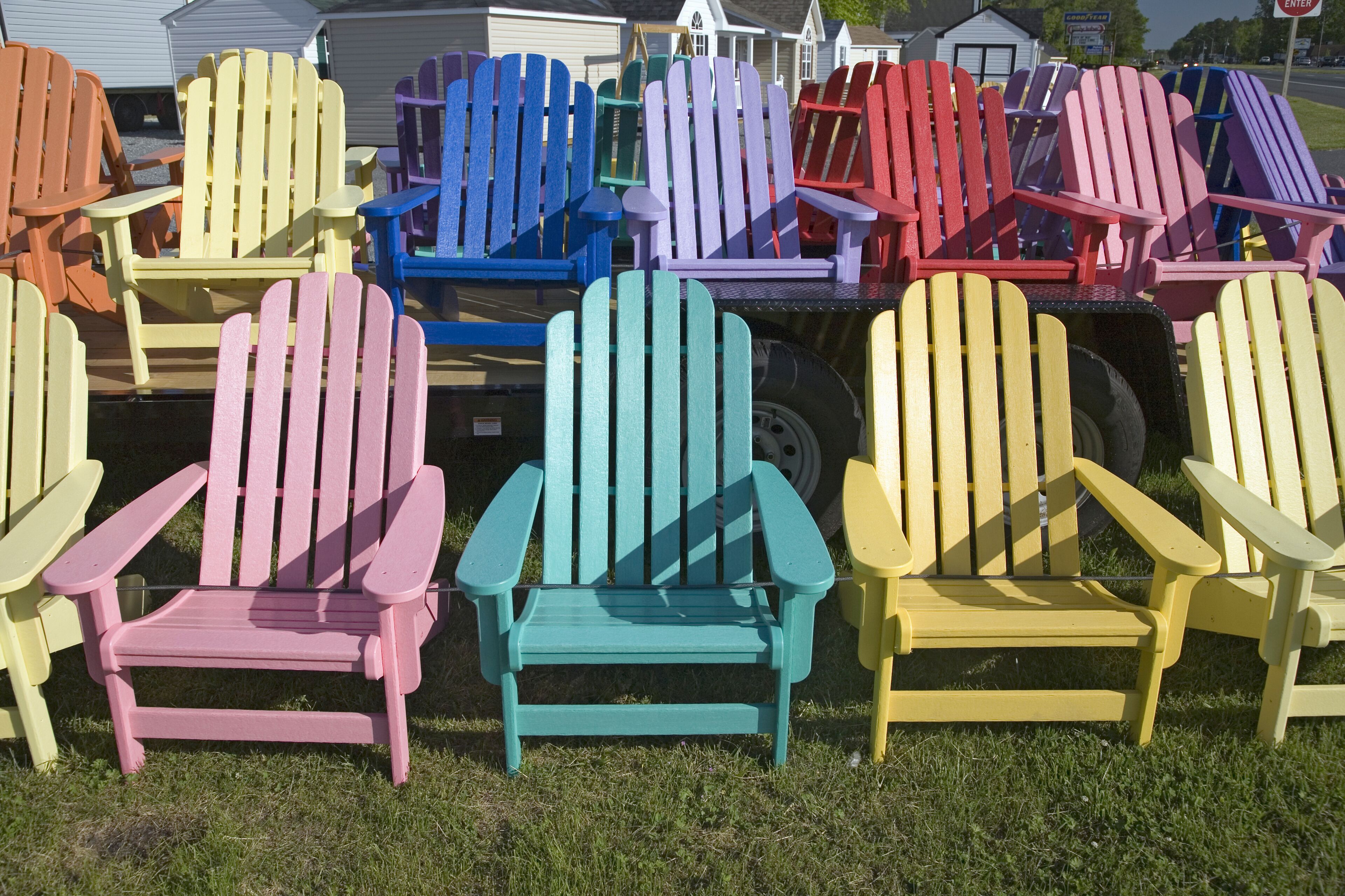 Rainbow colored wooden chairs, known as Maine Chairs, standing in a row outside on the Eastern Shore, Maryland