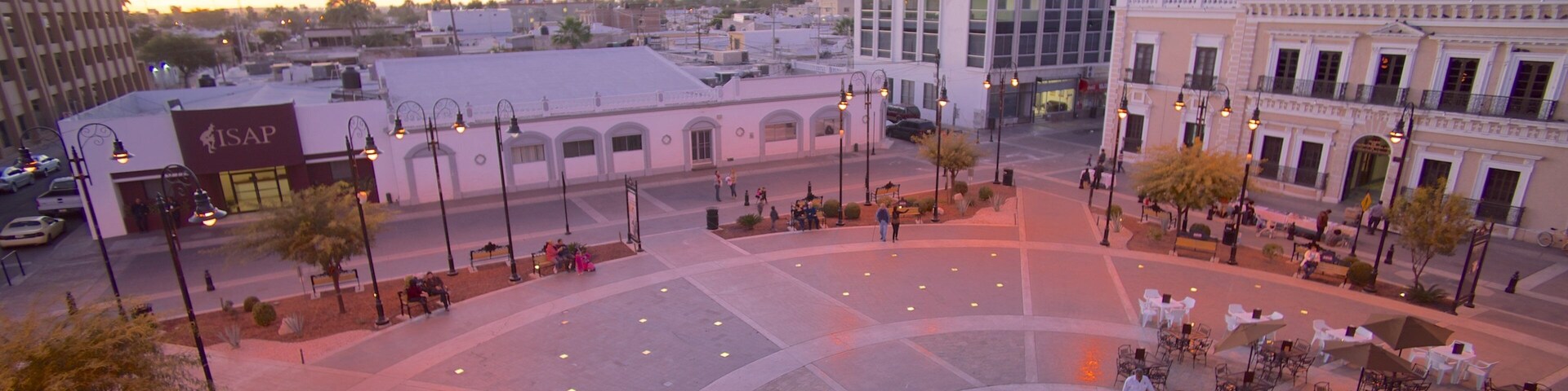 A plaza with a circular fountain, benches, and outdoor seating areas.
