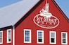 A red building with the sign "Icy Strait Point Hoonah, Alaska" and a sailboat illustration.