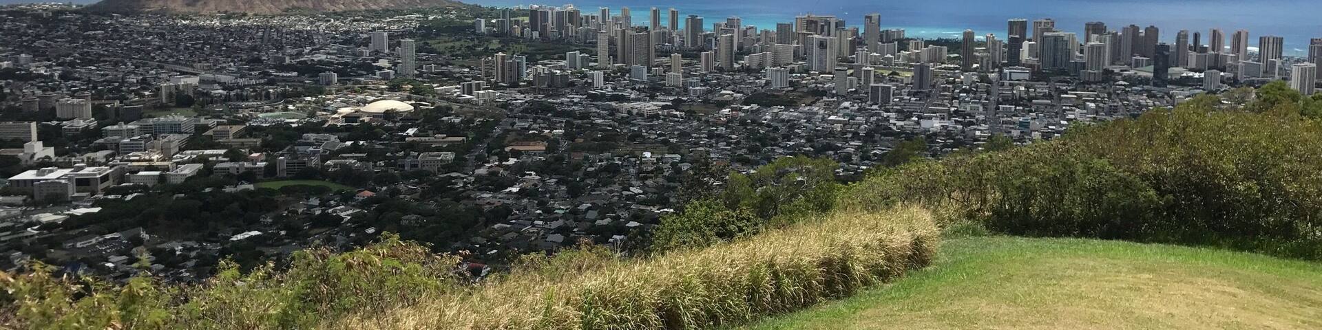 Un paisaje urbano costero con una montaña al fondo y un cielo despejado.