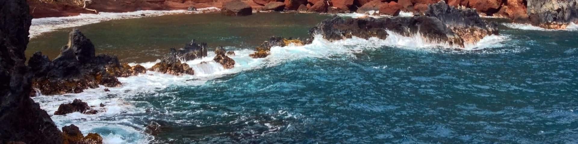On the back side of Ka'uiki Hill in Hana, Red Sand (Kaihalulu) Beach is just a five minute hike, but steep drop offs and loose gravel from this cinder cone make it a treacherous trip. Not for the faint of heart or perpetually clumsy, but daring adventurers are rewarded with dramatic red cliffs and a cerulean blue cove providing a sheltered swimming area.