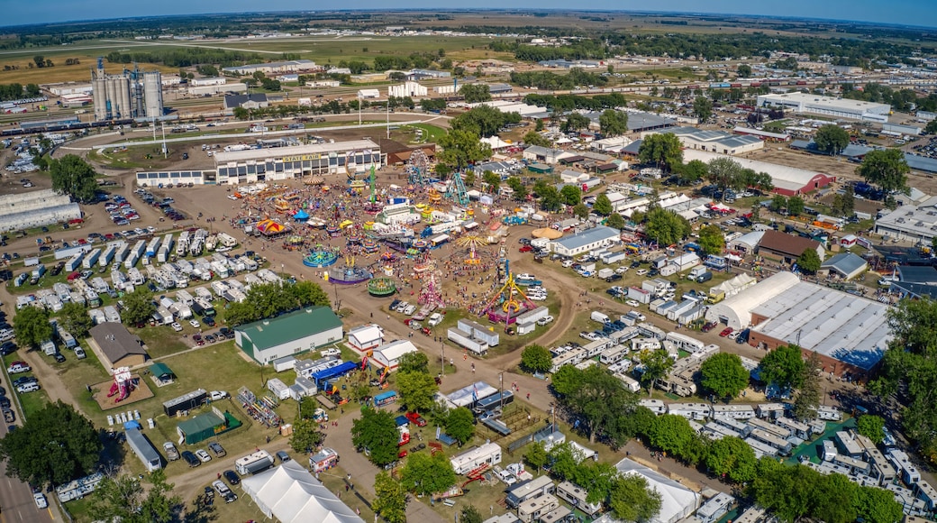 An aerial view of a fairground with a Ferris wheel, tents, and RVs.