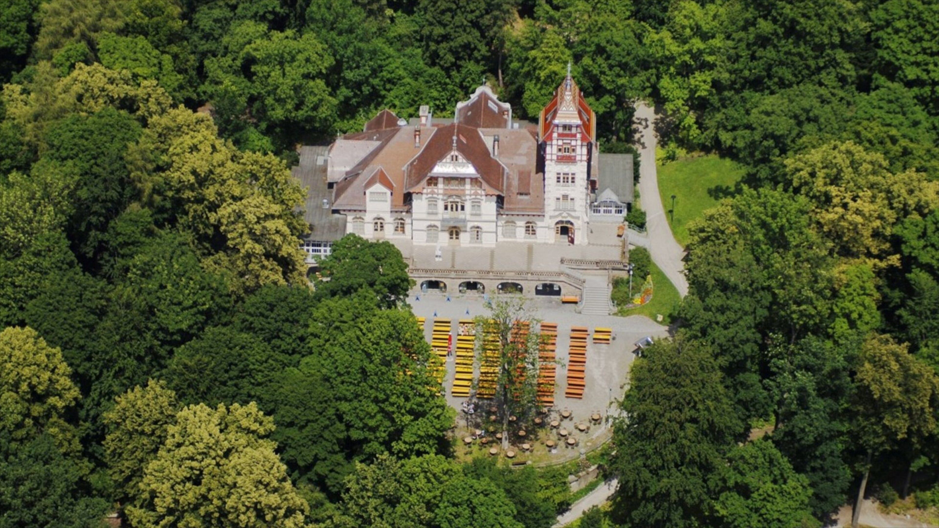 An aerial view of a historic castle surrounded by dense forest.