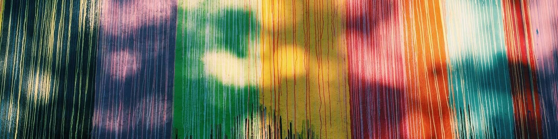 A colorful, abstract pattern with vertical lines and streaks of various colors.