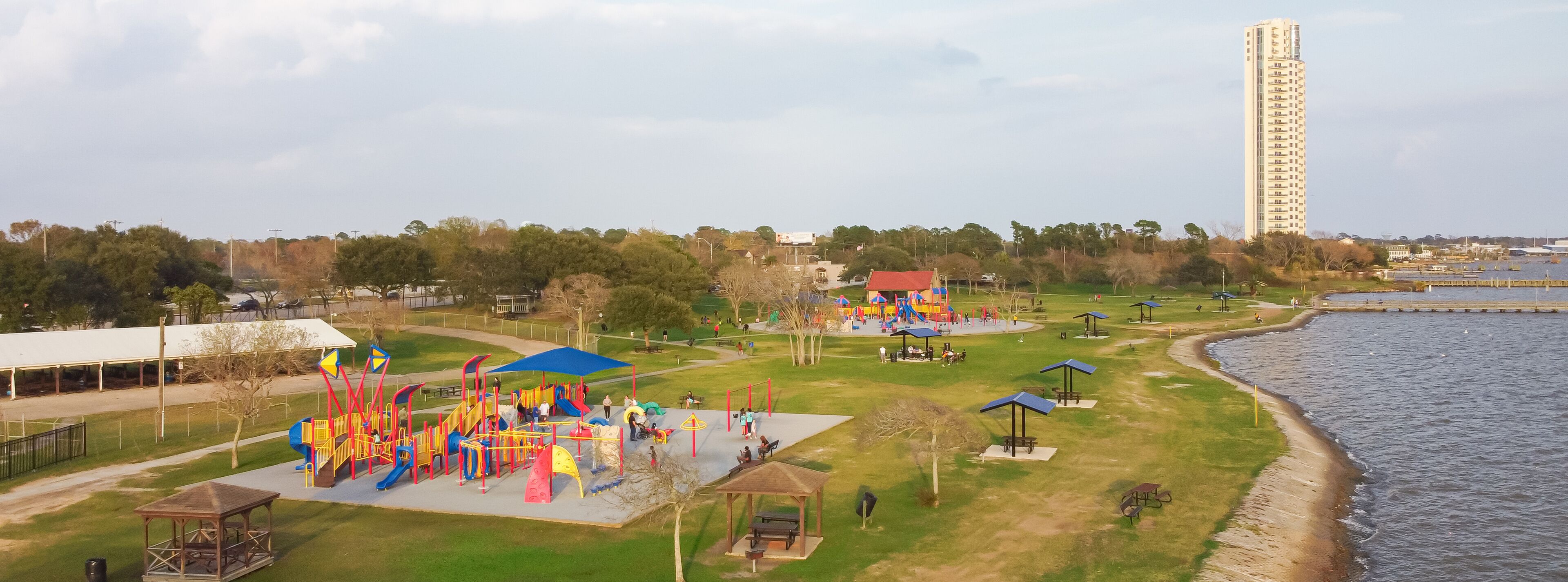 Panorama aerial view modern high-rise tower and public park playground with lakefront setting, Bay Area, Clear Lake Park, Seabrook, Texas, dynamic intersection of recreation and metropolitan life