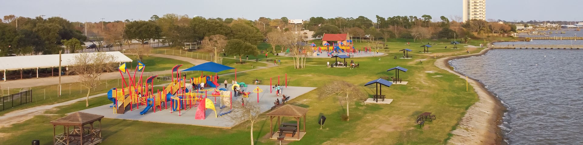Panorama aerial view modern high-rise tower and public park playground with lakefront setting, Bay Area, Clear Lake Park, Seabrook, Texas, dynamic intersection of recreation and metropolitan life