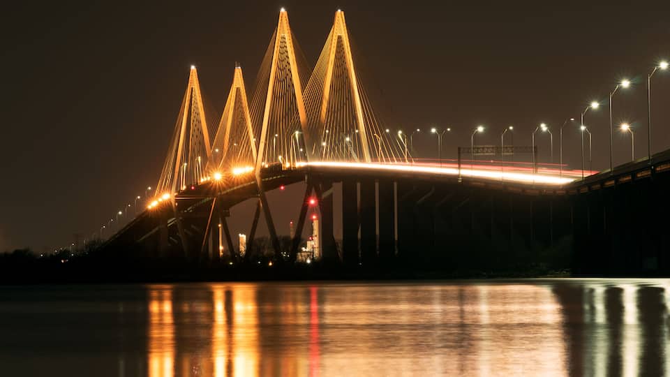 A bridge with illuminated cables at night.