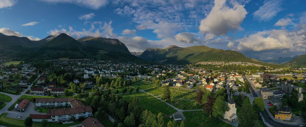 A town nestled in a valley with mountains in the background.