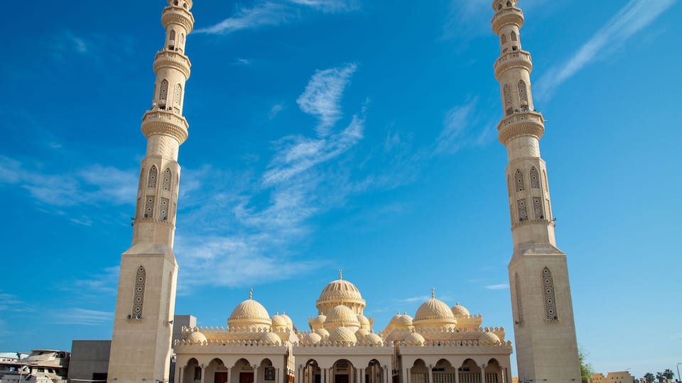 A mosque with two tall minarets, multiple domes, and a large courtyard.