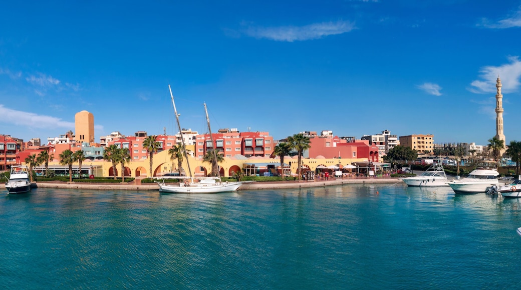 Panoramic view from the marina of Hurghada to the minarets of the El Mina mosque and the city's embankment with moored yachts, shops, cafes and a pedestrian zone for walking