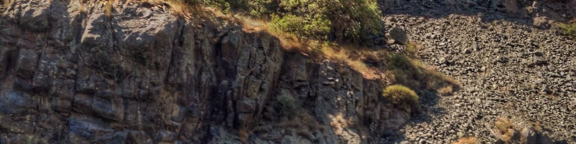 Un cañón rocoso con un río en su base.