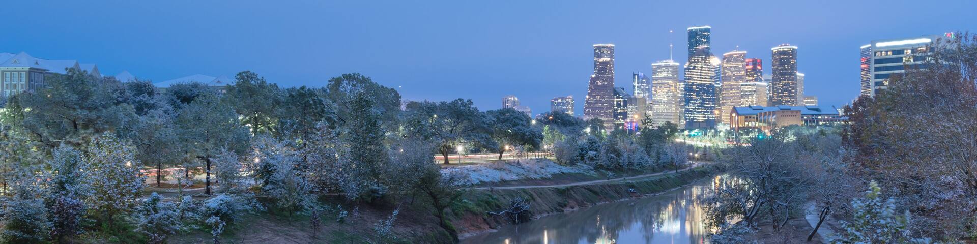 Panorama view unusual snowfall along Bayou River bank with downtown Houston, Texas, USA skylines city lights reflection at sunrise/twilight. Snow is extremely rarely and happen only 35 time since 1895