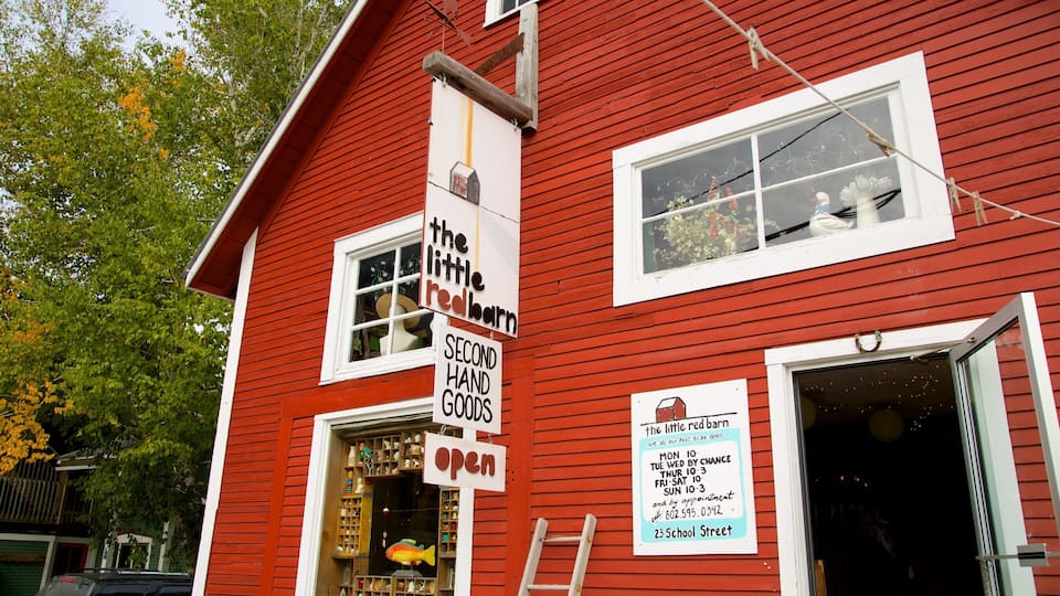 A red building with signs advertising 'The Little Red Barn' and 'Second Hand Goods'.