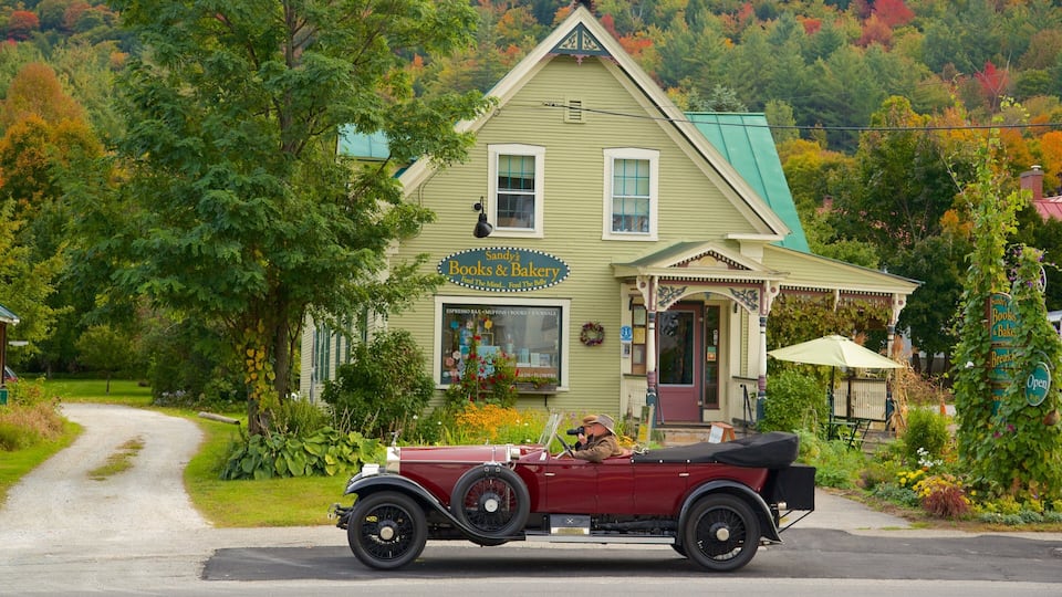 A vintage red convertible parked in front of Sandy's Books & Bakery.