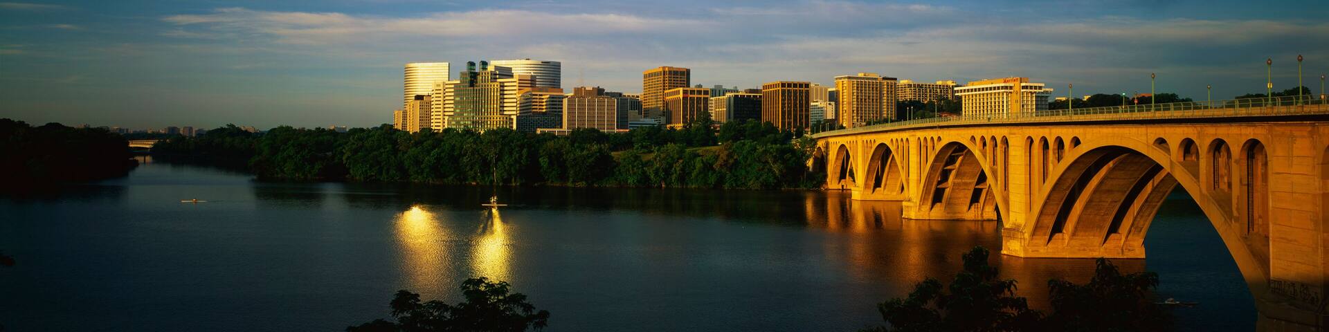 This shows sunrise over the Key Bridge on the Potomac River. The skyline of Rosslyn, Virginia is in the background.