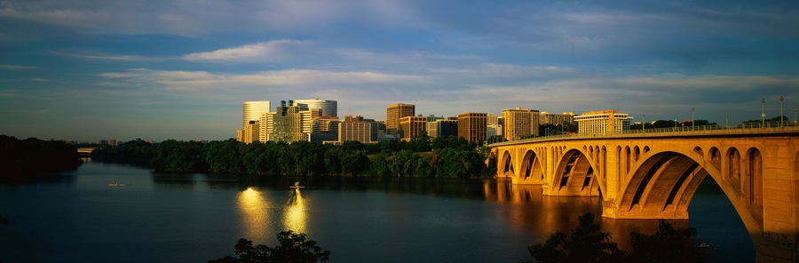 This shows sunrise over the Key Bridge on the Potomac River. The skyline of Rosslyn, Virginia is in the background.