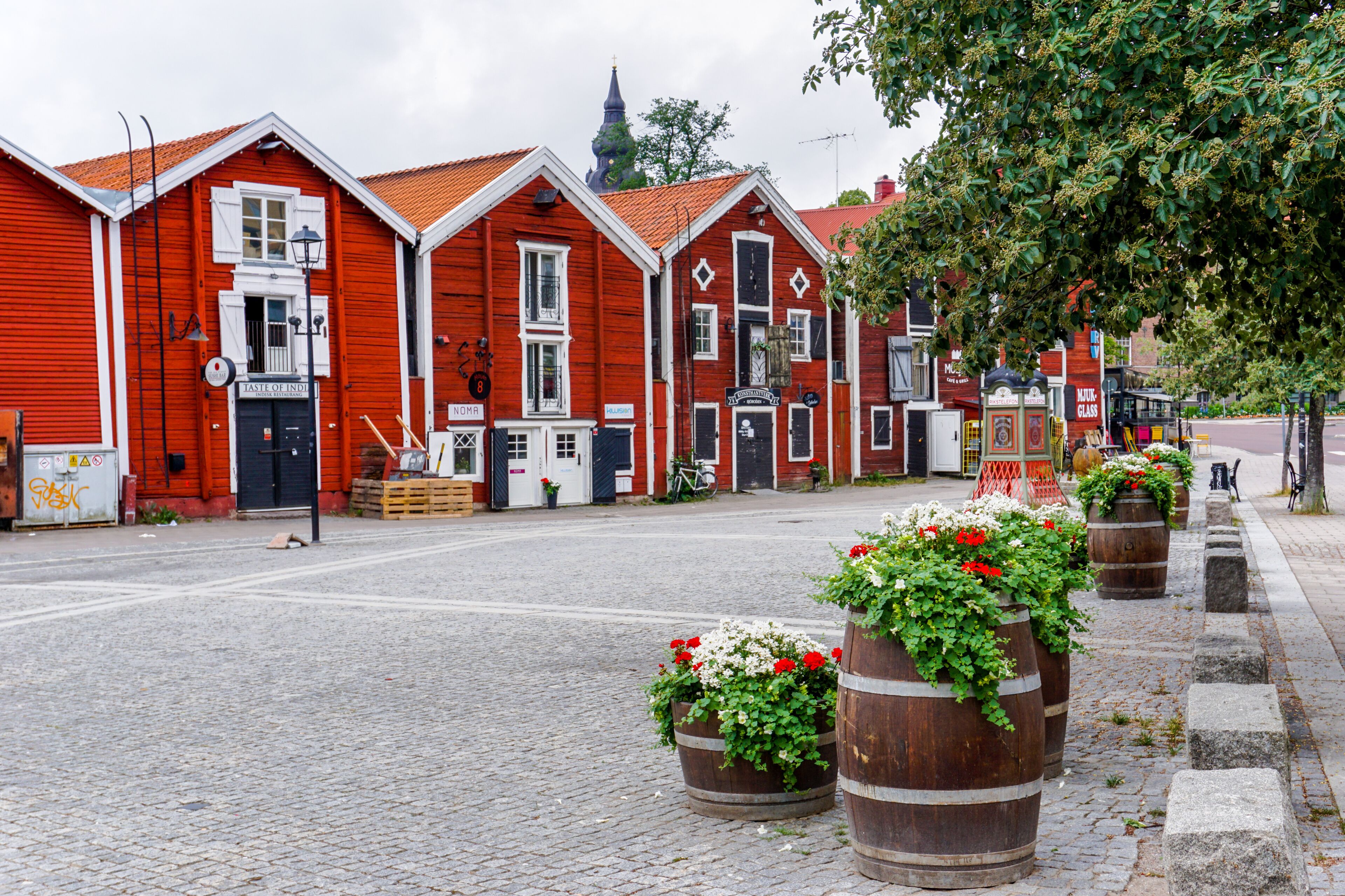 colorful wooden buildings line the canal in downtown Hudiskvall
