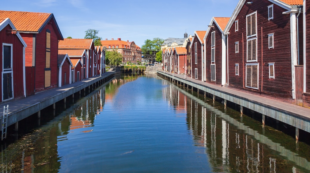 A canal flanked by red wooden houses with white trim and orange roofs.