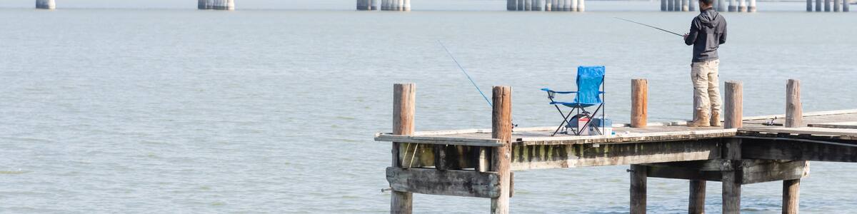 Unidentified fisherman fishing from pier jetty at Lake Ray Hubbard near Dallas, Texas, USA