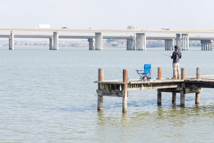 Unidentified fisherman fishing from pier jetty at Lake Ray Hubbard near Dallas, Texas, USA